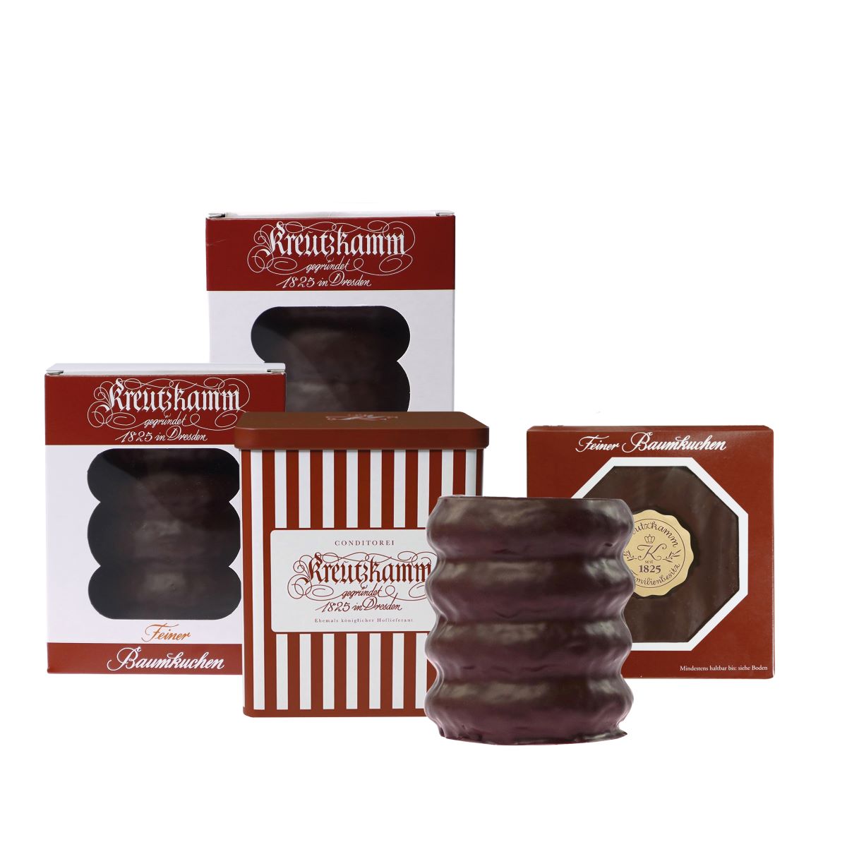 Mehrere Verpackungen mit der Aufschrift Kreutzkamm feiner Baumkuchen vor weissem Hintergrund.