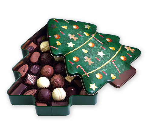 Baumfoermige Dose voller Pralinen, die geoeffnet ist. Deckel zeigt weihnachtliche Muster.