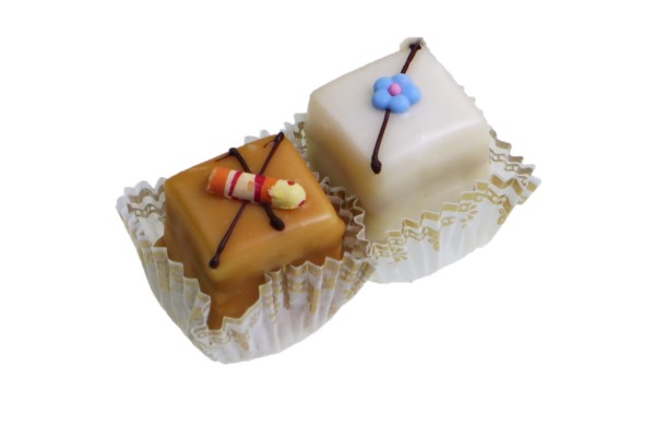 Petit-Fours-lose Zwei bunte Petit Fours in Papierfoermchen; links braun mit Deko, rechts weiss mit Blume.