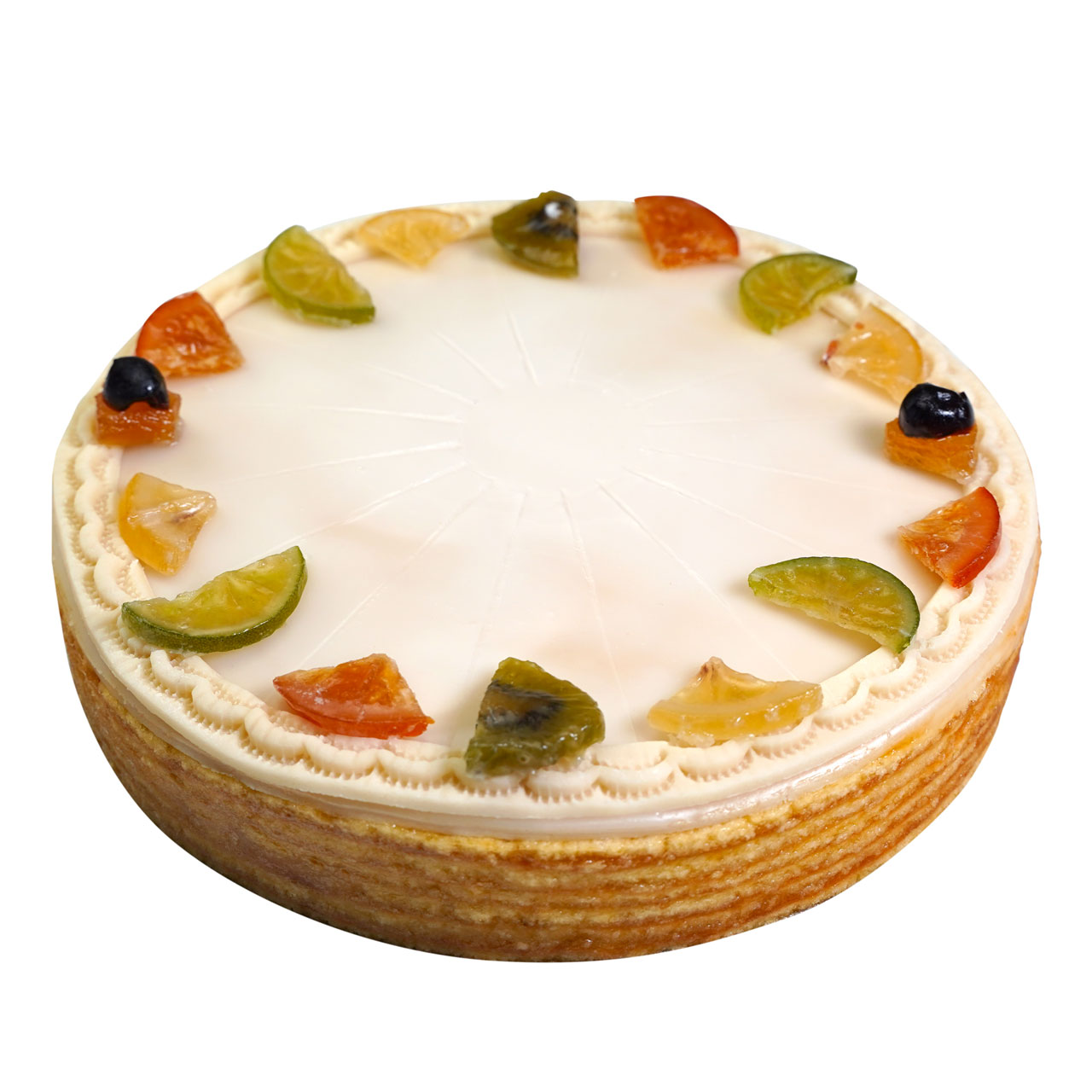 Ein Kuchen mit weisser Glasur und kandierten Fruchtstuecken auf dem Rand vor weissem Hintergrund.