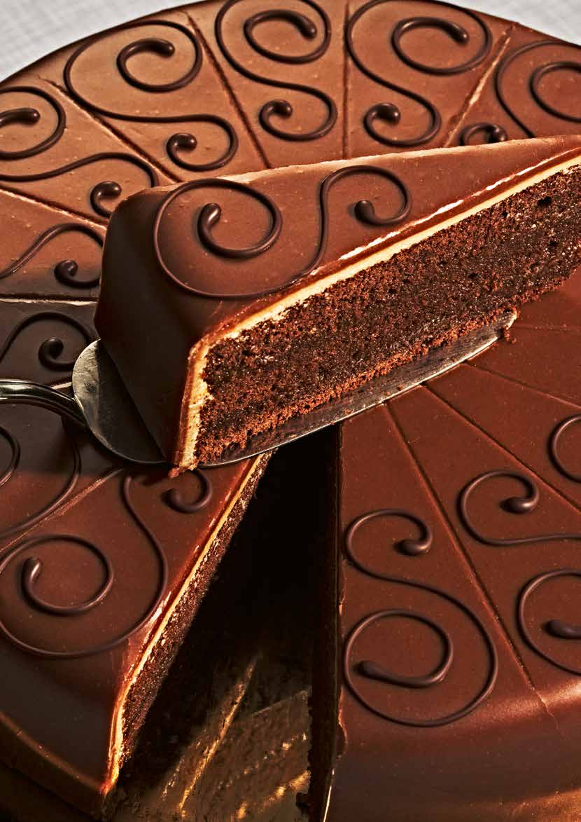 Buchvorstellung-Kreutzkamm-Backbuchau8TQQ8XKUCbB Ein Schokoladenkuchen wird geschnitten. Spiralmuster verzieren die Oberseite des Kuchens.