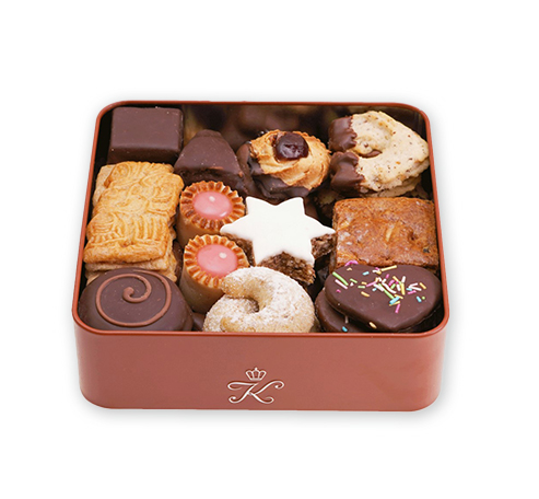 Eine rotbraune Schachtel mit gemischtem Gebaeck und Pralinen, mit einem weissen "K" darauf.